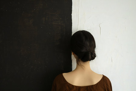 Back view of a young woman standing in front of a blackboardの素材