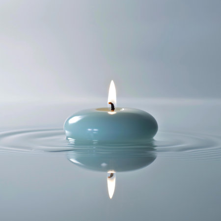 Burning candle on a white background with water ripples and wavesの素材