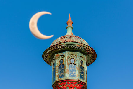 Crescent moon on the dome of a mosque with blue sky backgroundの素材