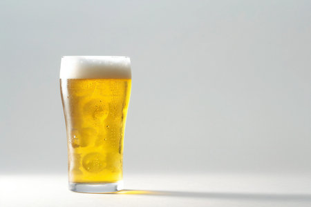 Glass of beer with foam on a white background with copy space.の素材