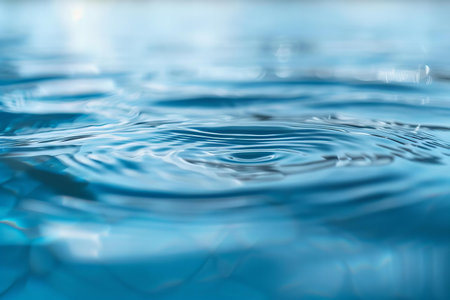 Water drop close-up with ripples and waves on blue background