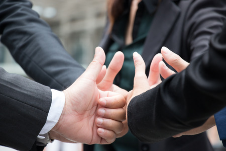 team give thumbs up sign for teamworkの写真素材