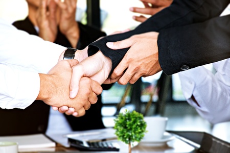 businessmen are shaking hand with people clapping hand