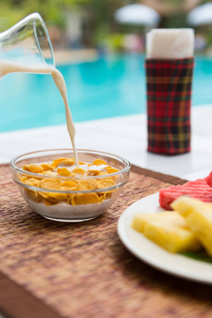 bowl of sugar-coated corn flakes and milk