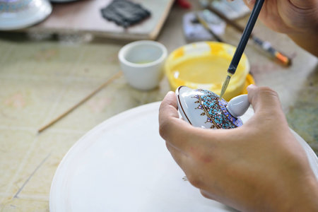 Thai people working process paint Ceramic Benjarong is traditional Thai five basic colors style pottery at workshopの写真素材