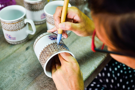 CHAINAT, THAILAND - OCTOBER 17, 2014 : Thai people working process paint Ceramic Benjarong is traditional Thai five basic colors style pottery Thailand.のeditorial素材