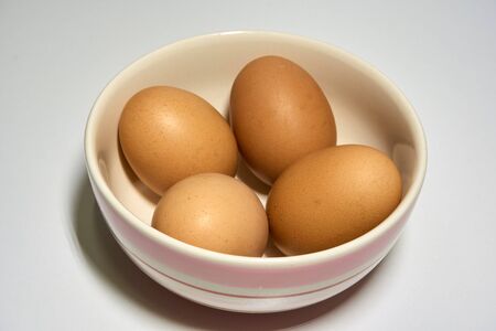 Eggs in a bowl on white backgroundの写真素材