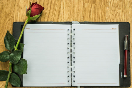 Blank paper and rose on wooden. View from aboveの写真素材