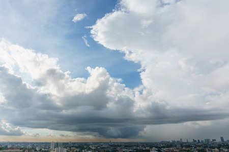 Big fluffy clouds floating in the sky above the cityの写真素材