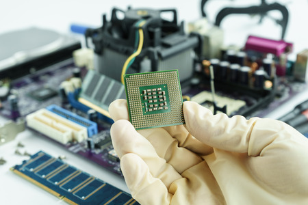 Hand hold CPU to check problem and repair or change new one into main circuit boardの写真素材