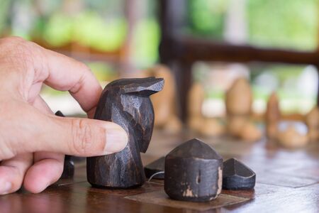 Man hand moving wooden chess on chess board