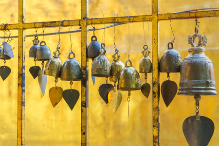 Small bells hanging on palisade in Buddhist temple, Golden bells in Thai templeの写真素材