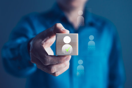 Businessman holding wooden block with human icon and green check mark, candidate selection, employee approval, recruitment decision-making, digital HR process, talent acquisition, modern businessの写真素材