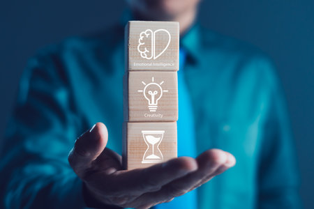 Businessman holding wooden blocks with icons of emotional intelligence, creativity, time management, essential soft skills, productivity, leadership mindset, innovation, professional self developmentの写真素材