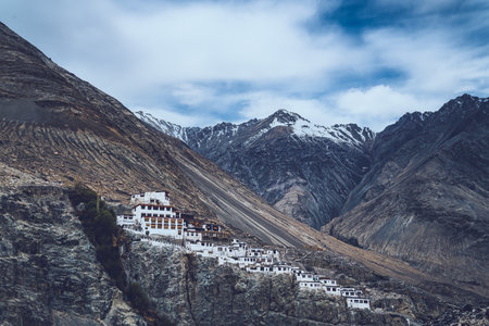 Ancient Buddhist monastery perched on rugged mountain cliffs of Ladakh, surrounded by dramatic Himalayan peaks and deep valleys, showcasing spiritual isolation and unique high-altitude architectureの写真素材