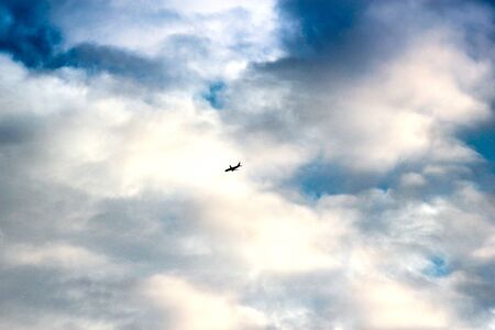 plane crossing a cloud vignetteの写真素材
