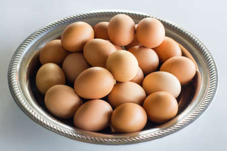 eggs in a metal bowl on a tableの写真素材