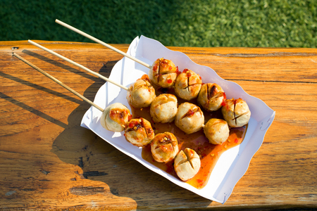 Grilled pork ball with sweet spicy sauce in paper trayの写真素材