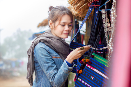 Tourist Asian woman shopping handmade souvenir or gift from Folk at Chiangmai Thailandの写真素材