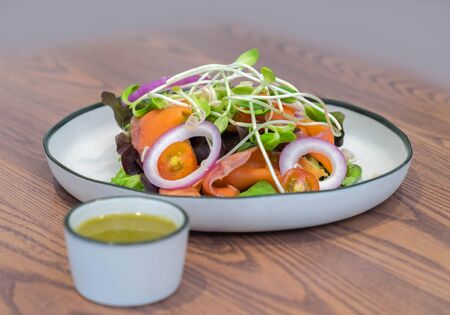 Sashimi salad fresh sliced of salmon with fresh mixed vegetable served with spicy sauce