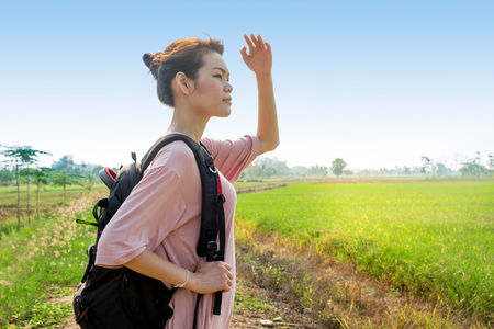 Traveler Woman with backpack looking landscape view at nature green rice field in evening day,tourism conceptの写真素材