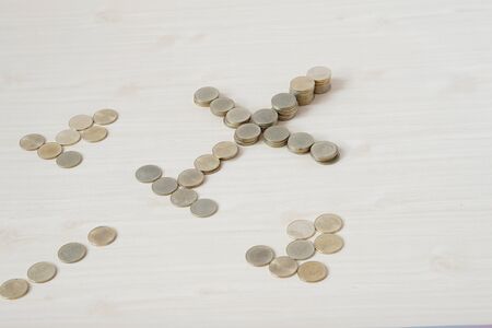 Pile of gold coins place as airplane on wooden table.
