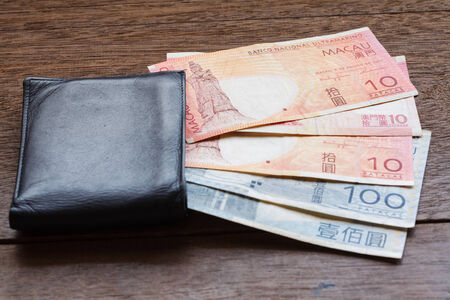 Ten and one hundred  Mop of Macau on old wooden plank with walletの写真素材