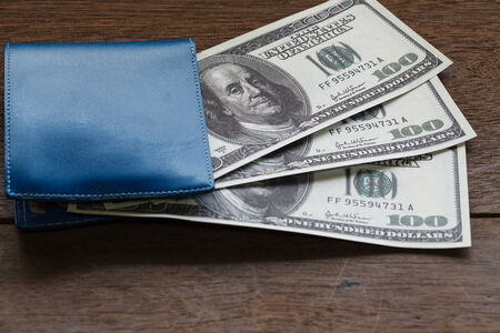 Hundreds of US dollars on old wooden plank with walletの写真素材