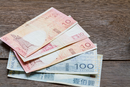 Ten and one hundred  Mop of Macau on old wooden plank with walletの写真素材