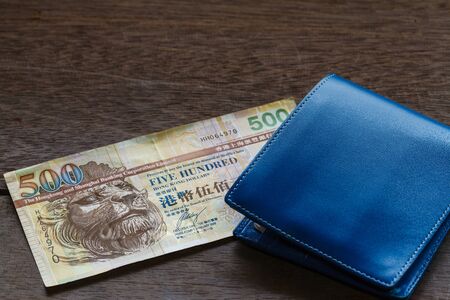 Five Hundreds of Hongkong dollars on old wooden plank with walletの写真素材