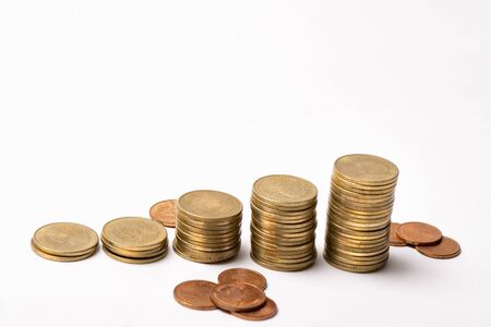Stacked golden coins and piles spread on a white background.