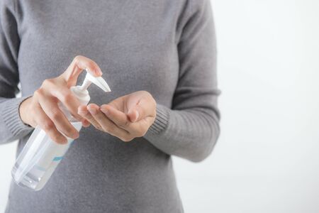 Female hands using washing hand with Alcohol Sanitizer isolate on a white background. Promoting people use face mask to protect themselves from virus infection in Coronavirus crisis 2020の写真素材