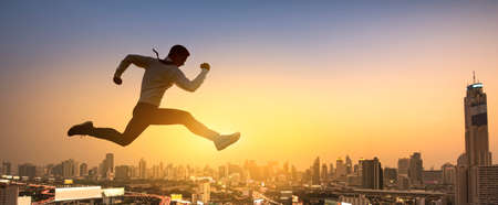 Young businessman jumping high, Work, job, or successful business concept. Cityscape background.