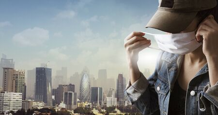 A tourist wearing a mask isolated on city background. Promoting people use face mask to protect themselves from virus infection in Corona virus crisis 2020の写真素材