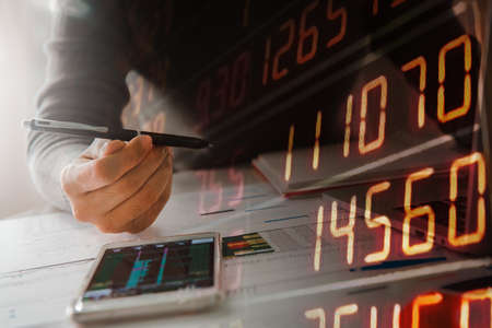 Businesswoman  holding pen, business documents, reports, graphs and charts of financial statements...