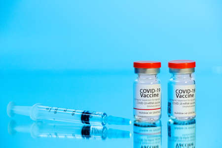 Ampoules with COVID-19 coronavirus vaccine, with a syringe for vaccination. Healthcare And Medical...
