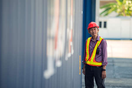 Foreman standing to rest at container in the container yard. Logistics concept .