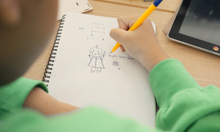 Student in international preschool writing a book together in Elementary School Class, Pupils enjoying studying in classroom.の写真素材