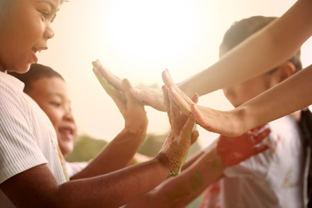 Happy children giving high five after a kid's plays outside in the evening.の写真素材
