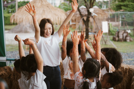 Group of children playing colourful water colours and colour stain on hand and dress. Happy children playing and painting water colour in class at school.の写真素材