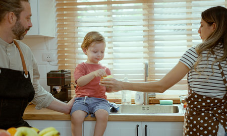 Happy family eating fruits in the kitchen.の写真素材