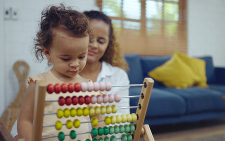 Mother and daughter are doing play a toy and having fun in living room.の写真素材
