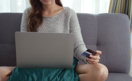 Close up of woman hands holding credit card and laptop. Young woman paying online using banking entering data shopping order in internet store secure payment.の写真素材