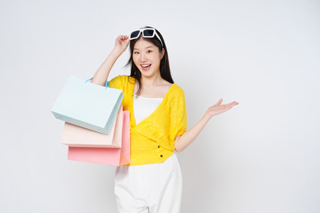 Happy young woman holding shopping bags isolated on white background.の写真素材
