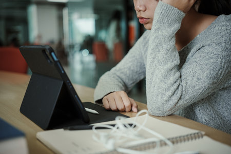 Asian student woman read books in library at university. Young girl stress tired have problem while...