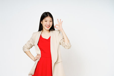 Young woman smiling and showing ok sign isolated on white background.の写真素材