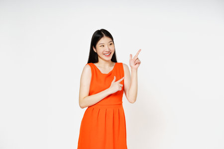 Young woman pointing up to copy space with smile face isolated on white background.の写真素材