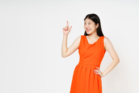 Young woman pointing up to copy space with smile face isolated on white background.の写真素材
