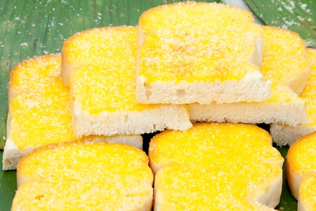 Toasted breads with butter and sugar on banana leaf