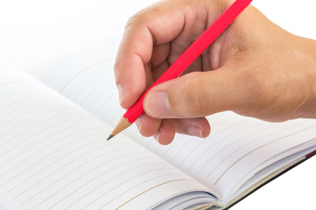 hand holding a pencil and book isolated on white backgroundの写真素材